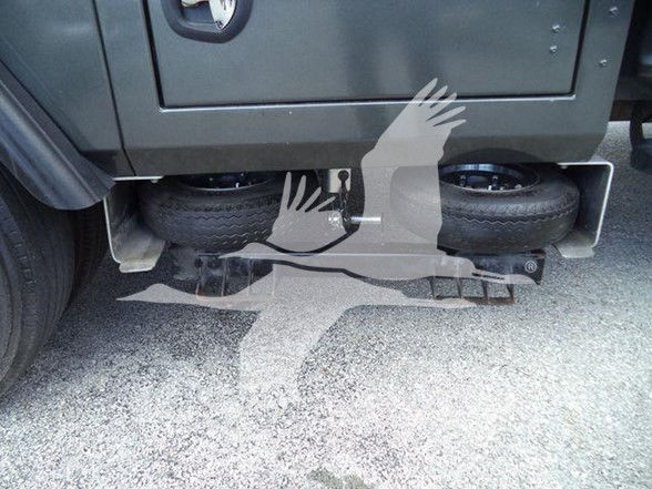 Tow truck undercarriage showing spare tires and underbody components.
