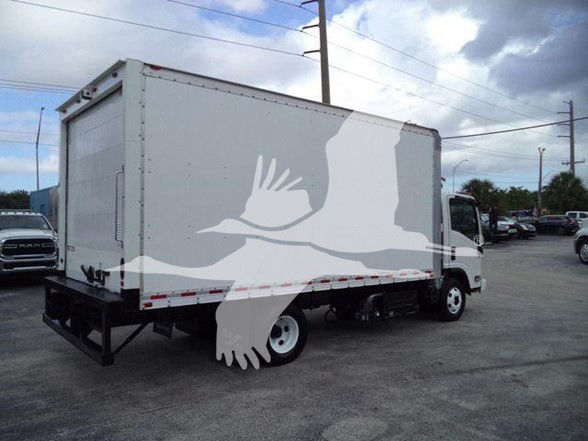 Isuzu NPR HD box truck in a used condition with a covered cargo box and rear bumper, side view.