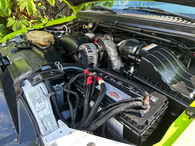 Ford F-550 engine bay with battery and hoses visible.