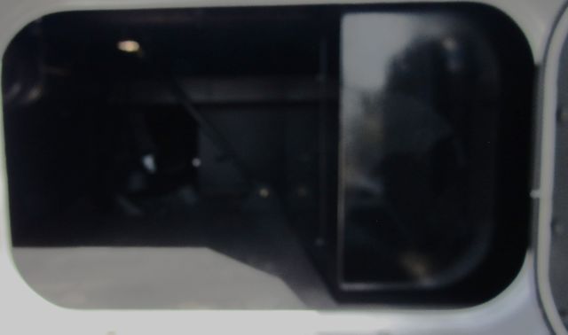 Kenworth T680 truck window view with dark tinted glass in cab and door frame. Shows side window and reflection.