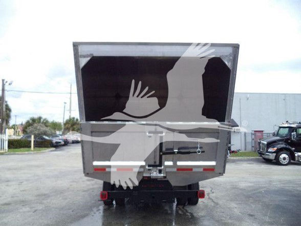 Truck bed rear view of a 2023 Chevrolet Silverado 6500HD with a chipper attachment in the bed; rear bumper and hitch visible.