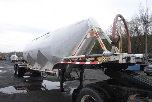 Fruehauf dry bulk trailer on a truck bed with hoses and hydraulic lines visible.