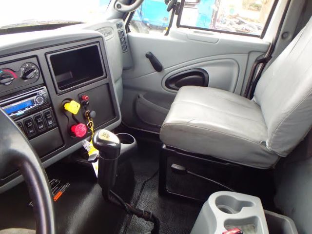 Interior of a 2007 International 8600 cab showing steering column, gear shifter, dashboard gauges, and gray driver seat.
