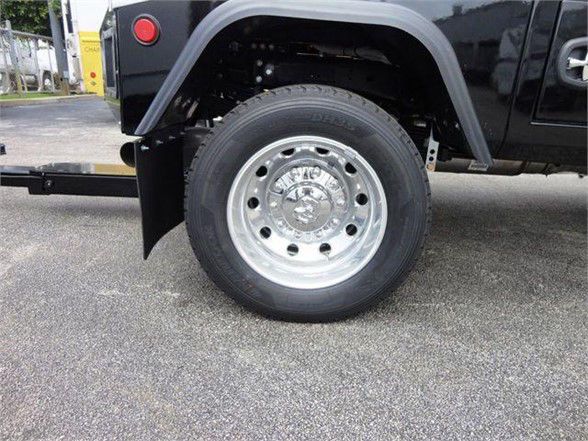 Ram 4500 SLT wheel well and front tire on a tow truck chassis. Chrome wheel with hubcap and lug nuts visible; black fender and part of towing equipment in background.