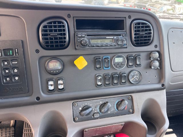 Cab interior of a 2015 Freightliner M2 showing dashboard controls, radio, air vents, gauges, and climate controls.