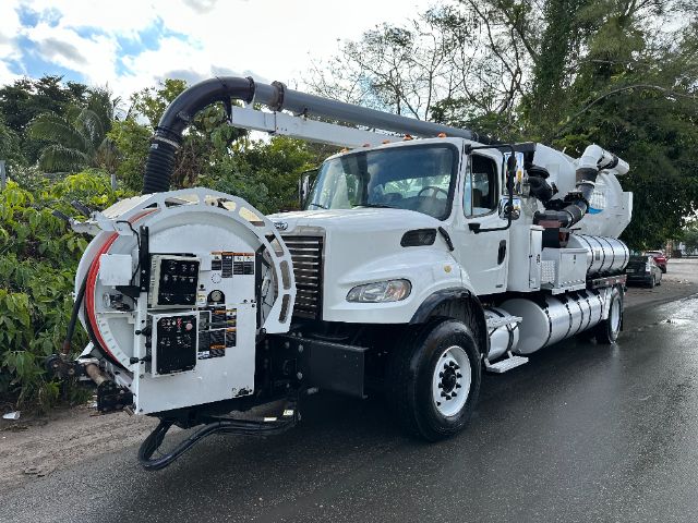 2011 Freightliner M2 vacuum truck with large front mount hose reel and factory cab. Visible text on rear equipment panels and control labels.