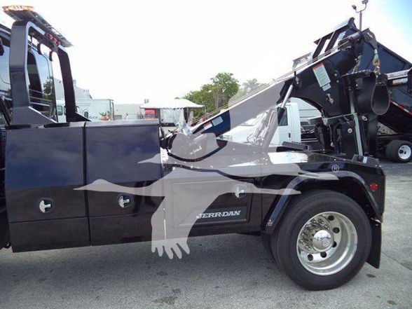 Tow truck side view showing International MV with hydraulic boom and wheel, text 'FERRN' or 'TERRAN' on door panel; no legible serials or numbers visible.