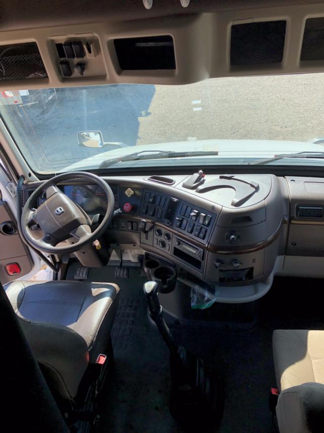 Volvo truck cabin dashboard and steering wheel with center console controls visible.