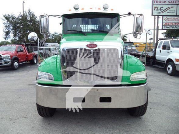 Front view of a green Peterbilt 348 truck with chrome grille, bumper, and big windshield. Blurry watermark overlapped.