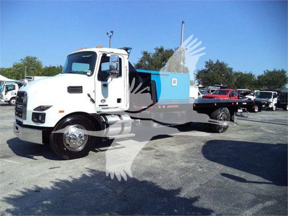 2024 Mack MD6 tow truck in a parking lot showing white cab and blue utility bed.