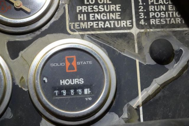 Truck crane dashboard gauge showing hours meter with 'Solid State' logo and mechanical readout.