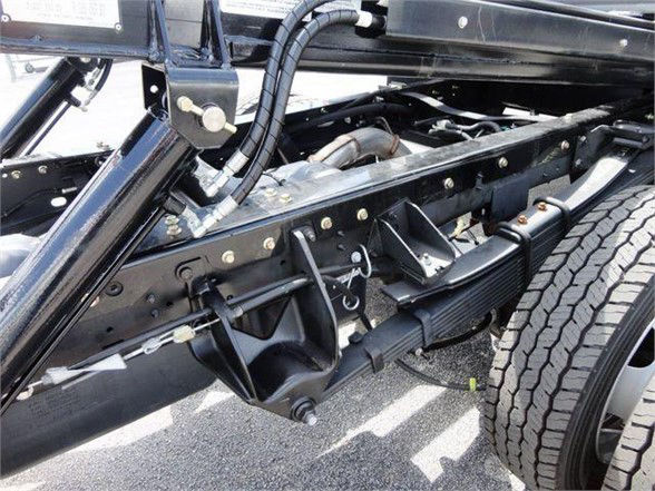 Ram 5500 chassis frame and suspension components visible under cab, including rear leaf springs, driveshaft, and wheel with tire.