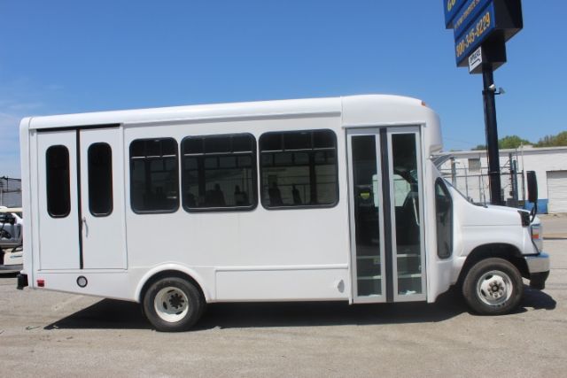 Ford E450 shuttle bus side view showing front entry door and windows.