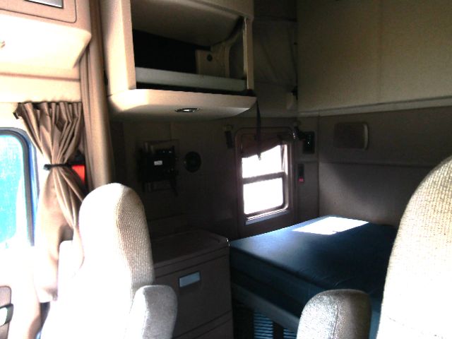 Kenworth T680 cab interior showing sleeper berth and passenger seats.