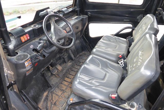 Kubota RTV-X1140 interior showing steering wheel, dashboard, and three-seat cabin with rubber floor mat.