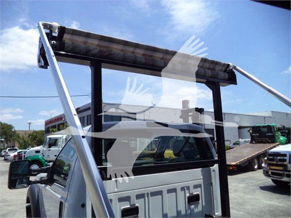 Ford F-550 pickup truck with a hydraulic lift gate and steel frame on the bed, side view showing cab and cargo area.