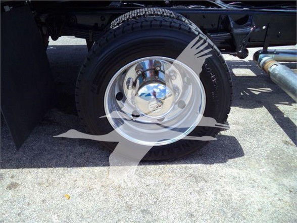 Truck wheel and tire assembly with chrome hubcap and steel rim in the wheel well of a 2023 Chevrolet Silverado 6500HD chassis.