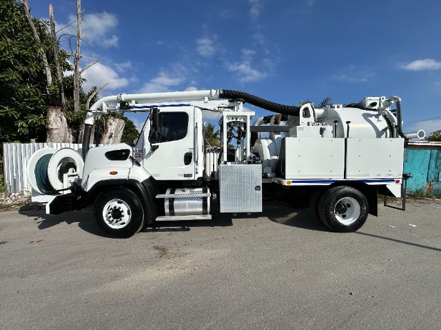 Freightliner 108SD vacuum truck with large rear vacuum hose and tanks, side toolbox, and front cab in serviceable condition.