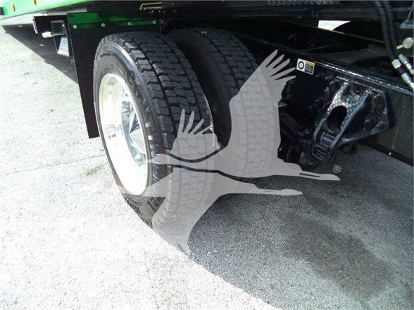 Truck rear dual wheels and suspension with a visible sticker on the frame; no explicit model text readable in image.