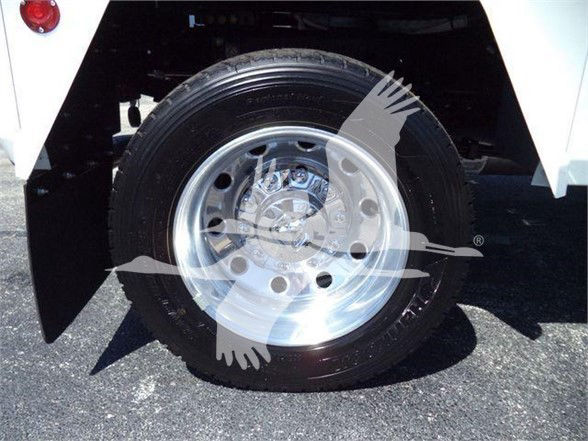 Front wheel and tire of a white Ram 5500 truck showing chrome rim and wheel well.