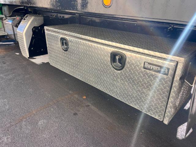 Aluminum diamond plate toolbox mounted under Freightliner M2 106 bed with two recessed handles and a Buyers logo plate.