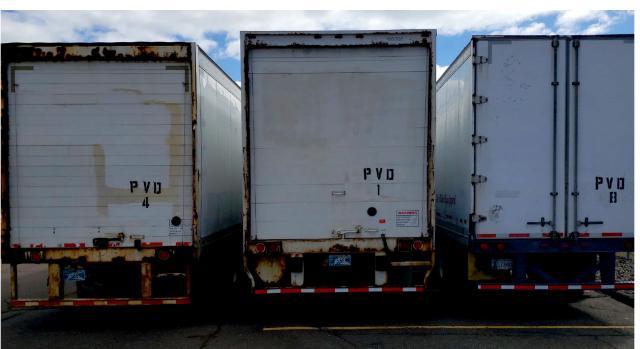 Trailer backs showing rear doors of three roll-off trailers with PVO markings.