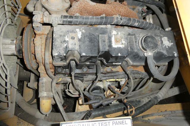 Truck crane engine bay showing valve cover, hoses, and wiring harnesses in a used Grove YB4410 crane.