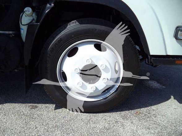 Isuzu NRR wheel and fender area with tire and wheel shown; no legible labels visible other than standard hubcap bolts.