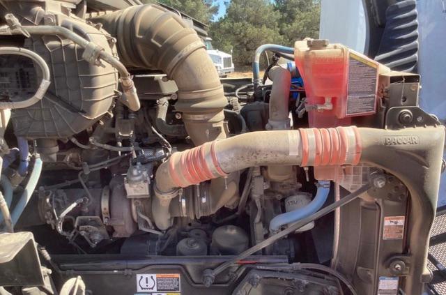 Peterbilt 579 engine bay showing air intake hose, radiator, coolant reservoir, and engine components.