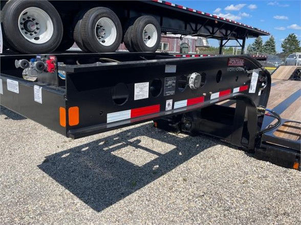 Black Fontaine 55 ton steel roller paver lowboy trailer with 24ft deck, dual rear axles, visible hydraulic components and reflective striping.