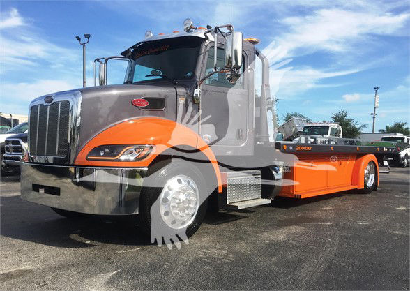 2022 Peterbilt 337 tow truck with gray cab and orange flatbed, chrome bumper, front grille, and side steps visible.