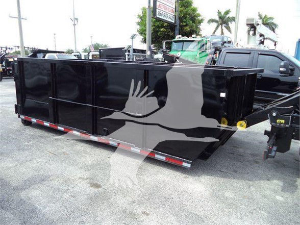Isuzu NRR truck with a large black dump bed trailer in a dealership lot. Side view shows rectangular black metal container with red-and-white reflective tape along bottom edge and yellow circular hitch on the right.