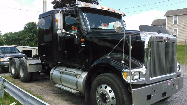 Black 2007 International 9900i semi-truck cab with chrome front grille and dual fuel tanks, side mirrors, and sleeper cab.
