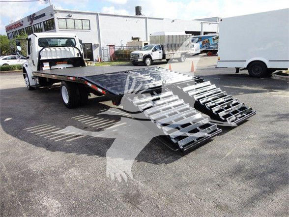 Flatbed tow truck with a ramp system attached, 2015 Freightliner BUSINESS CLASS M2 106, showing loading ramp details and a raised deck.