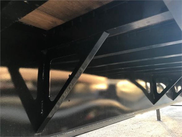 Trailer undercarriage showing structural cross members and support brackets.