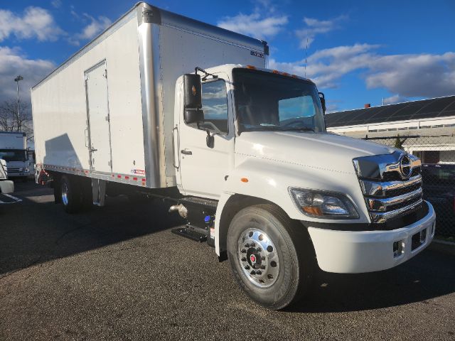 Box truck from a front-left view showing cab and box, Hino logo on grille, white exterior.