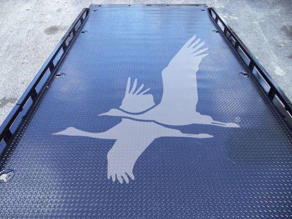 Platform bed with textured metal surface and a large white crane graphic in flight.