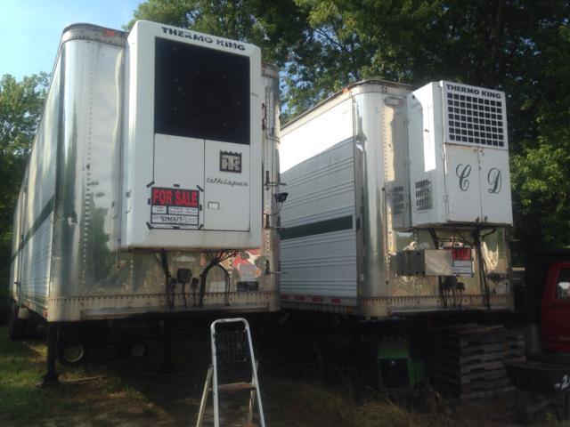 Two Thermo King reefer trailers mounted on trailers, one with a large black window/door, both with ‘FOR SALE’ sign and transfer units, outdoor storage.