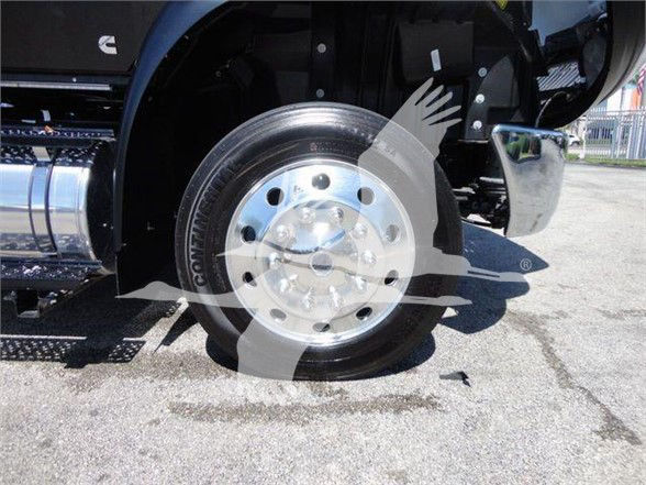Wheel and front fender of a truck showing a polished chrome rim and tire, with part of the chrome fuel tank and fender visible.
