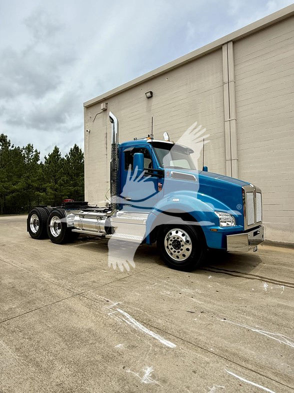 2026 Kenworth T880 conventional daycab truck in blue, side view showing chrome fuel tanks and chrome steps.