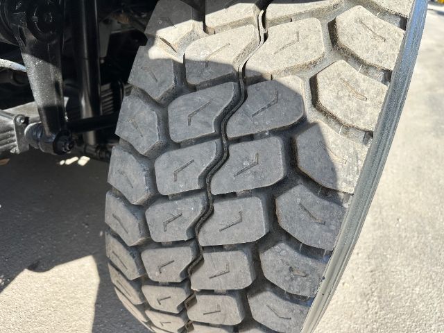 Tire tread close-up on a 2009 International 7500 vacuum truck showing chunky off-road tires.