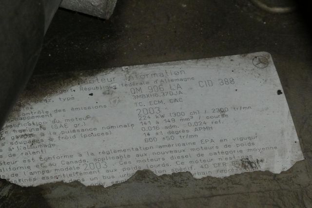 Label with vehicle information plate showing emissions data, engine type, power, and various numbers, partially faded but legible text in French/English.