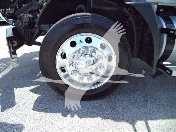 Vehicle wheel and tire assembly with chrome hub, part of Mack MD6 chassis.