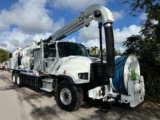 2014 Freightliner 114SD vacuum truck with front cab, large reel and hose boom, white exterior, blue hose reel, side compartments.