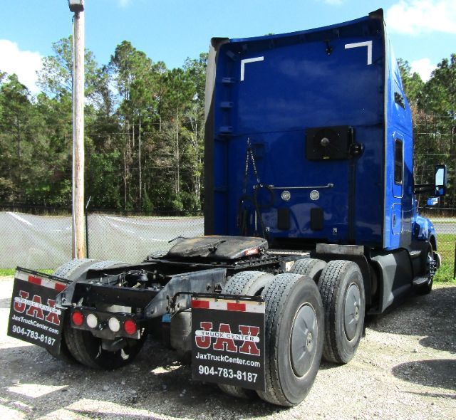 Kenworth T680 truck cab and chassis rear view showing blue cab, rear wheels, and fifth wheel area.