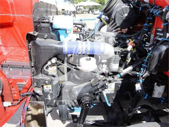 Peterbilt 337 engine bay showing coolant reservoir, hoses, and various engine components in red truck.