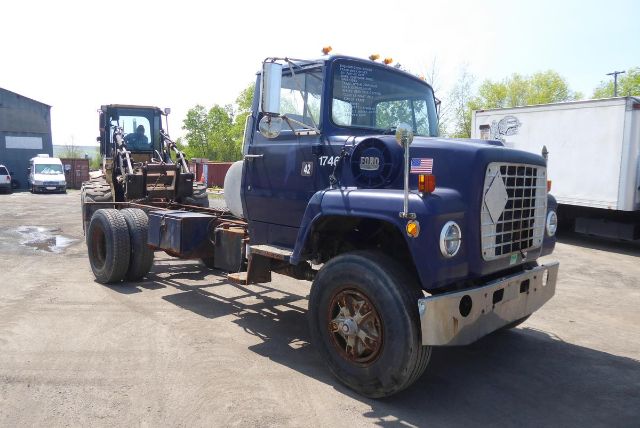 Ford 8000 cab and chassis truck in blue with front grille, dual headlights, and large side mirrors; chassis and missing bed visible.