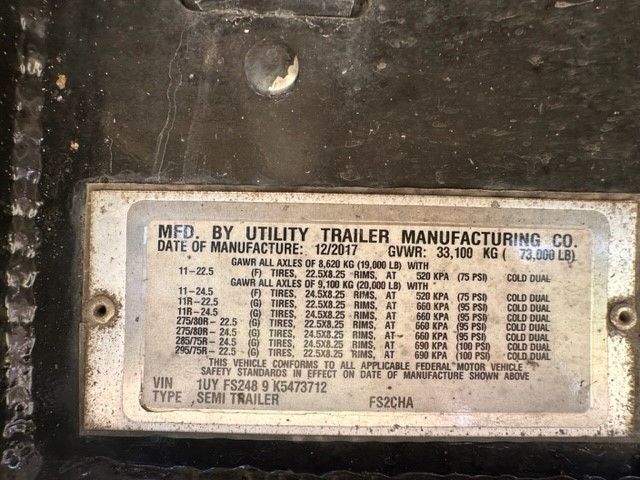 MFD. BY UTILITY TRAILER MANUFACTURING CO plate with date of manufacture 12/2017 over a dark trailer surface; VIN 1UYFS2489K5473712; GVWR 33,100 KG; various tire and axle specifications visible