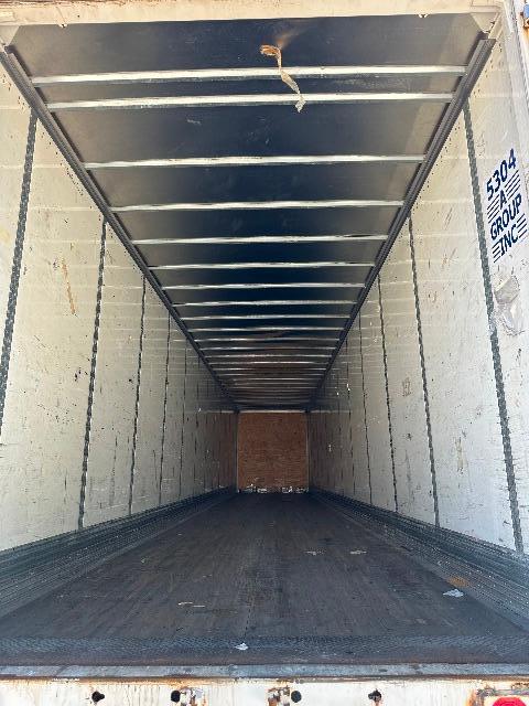 Trailer interior: long Wabash DuraPlate dry van cargo area with metal ceiling ribs and side walls, dark non-slip floor, open at rear.