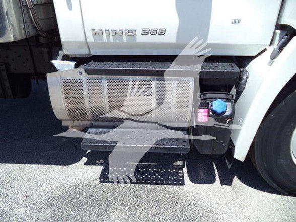 Front left side of a white truck with Hino 268 badge; large metal perforated step/step guards; black fuel/auxiliary tank with blue cap; pink label; port side.